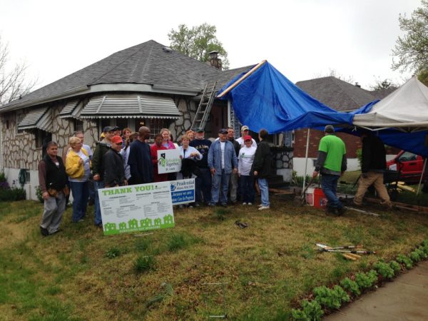The crew of volunteers pose with the homeowner (in the middle holding sign) for a photo during National Rebuilding Day in St. Louis, Mo.