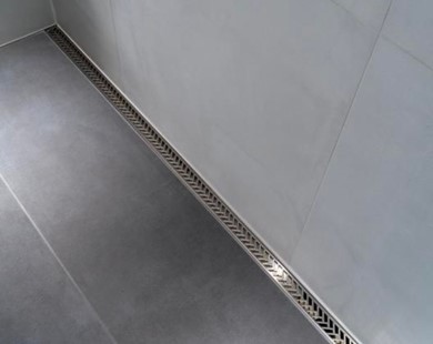 A close-up of a drain in a bathroomDescription automatically generated